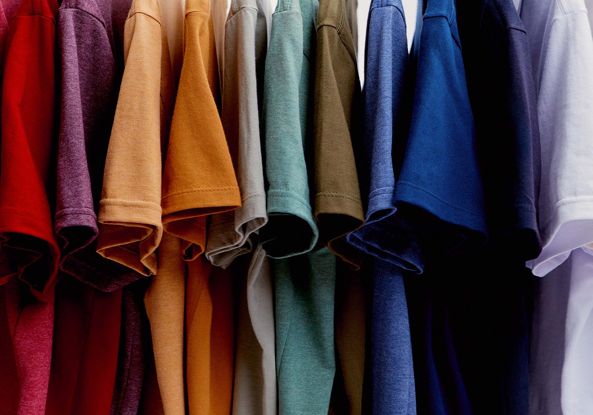 Camisetas coloridas penduradas em cabides