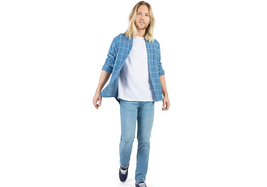 modelo veste camisa xadrez azul branca t-shirt branca calça jeans lavagem clara 
