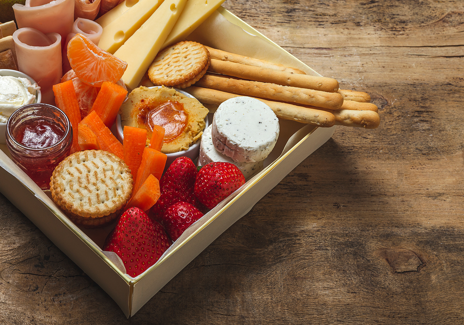 Tábua de frios com queijos, frutas e biscoitos