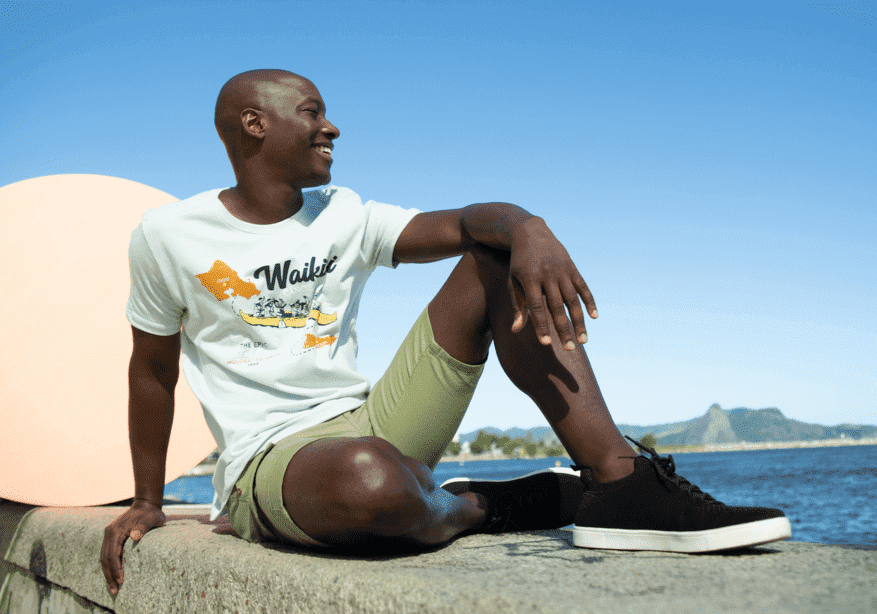 modelo sentado a beira mar sorrindo