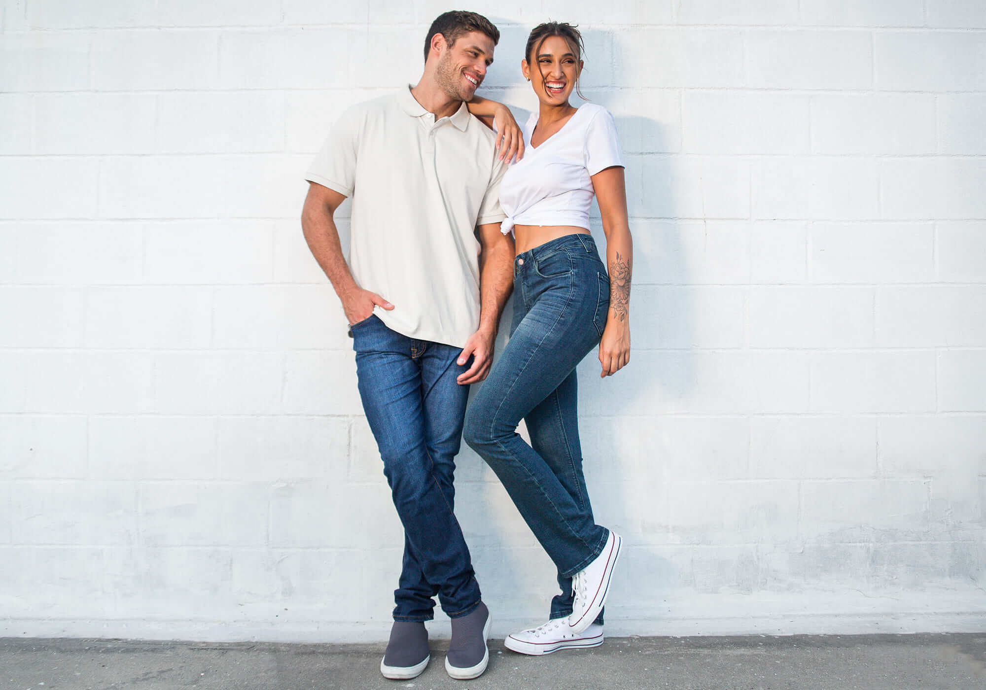 homem e mulher com calça jeans e camisetas brancas