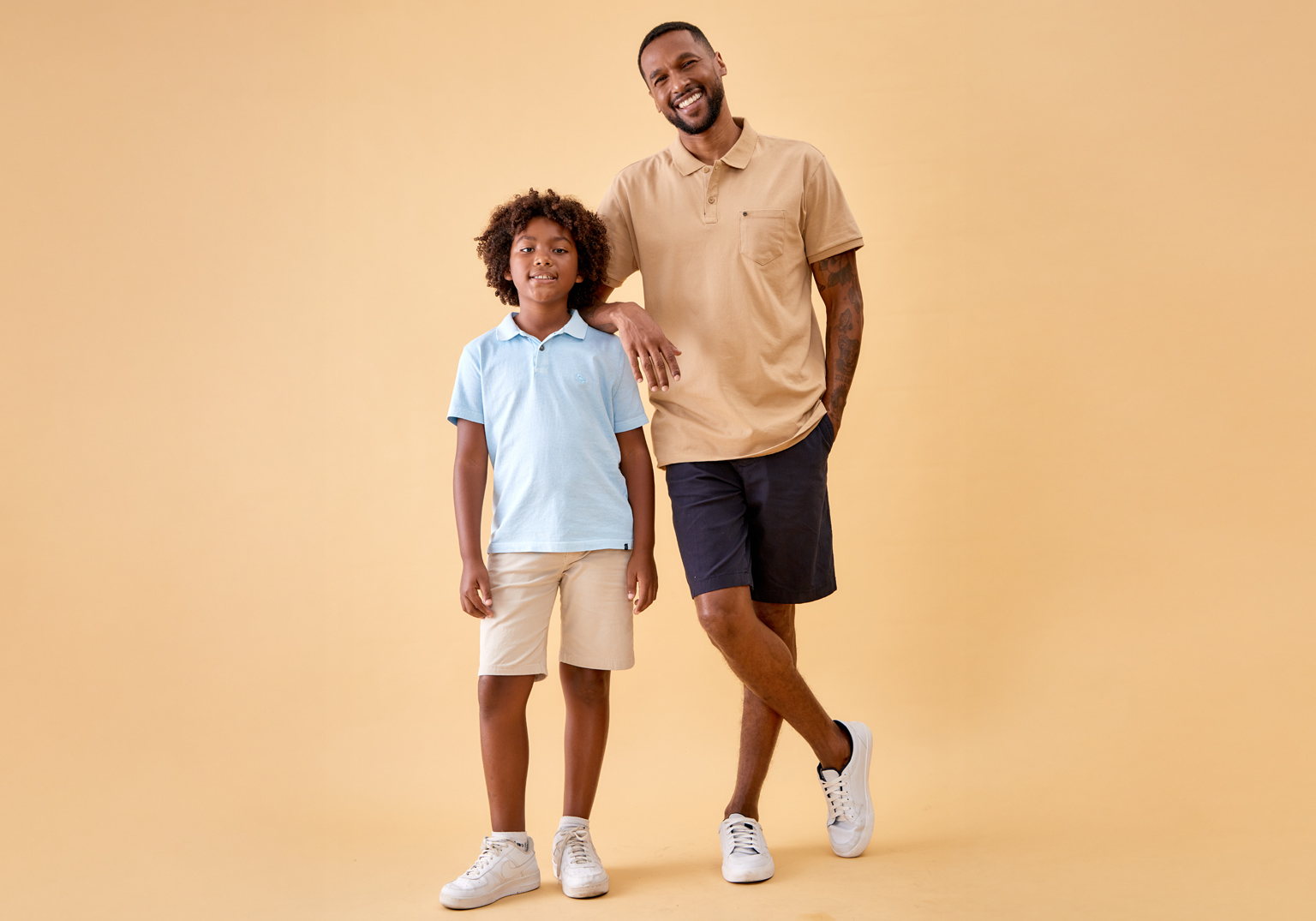 Foto de pai e filho sorrindo em fundo amarelo