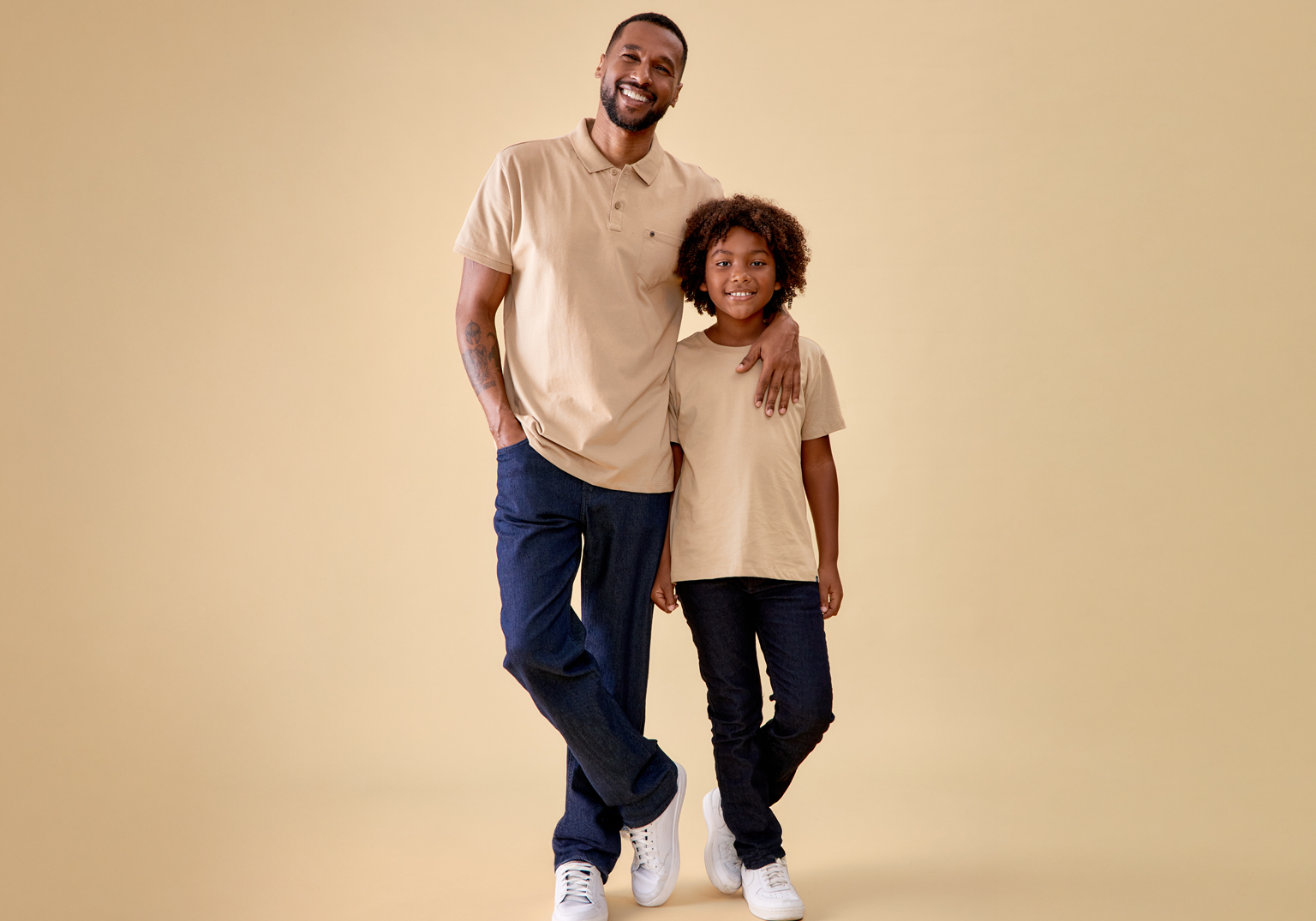 Foto de pai e filho sorrindo em fundo amarelo