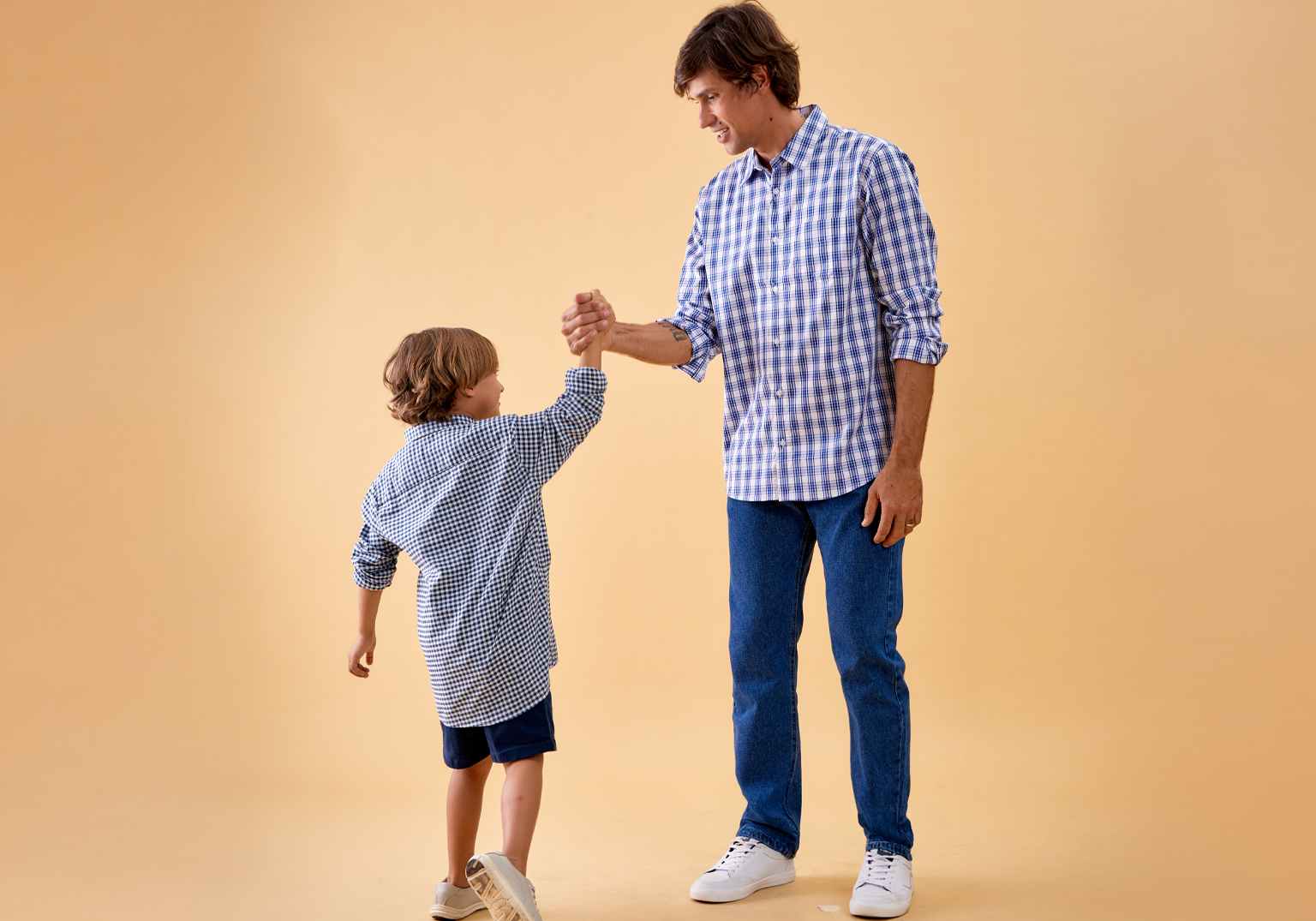 Pai e filho usando camisetas xadrez sorrindo